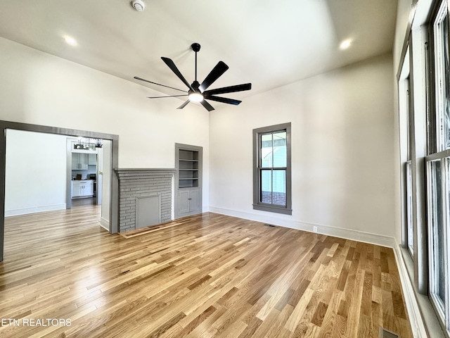 304 Broad St, Sweetwater, TN 37874 - unfurnished living room with light wood-type flooring, baseboards, a high ceiling, visible vents, and ceiling fan with notable chandelier