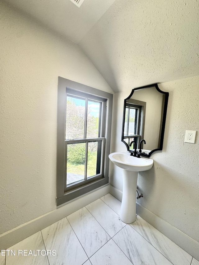 304 Broad St, Sweetwater, TN 37874 - bathroom with a textured wall, baseboards, marble finish floor, and vaulted ceiling