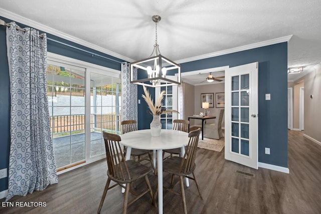 dining space with wood finished floors, ceiling fan with notable chandelier, baseboards, and ornamental molding