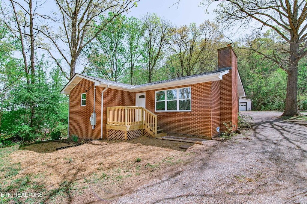 view of front of property with brick siding, a garage, and a chimney