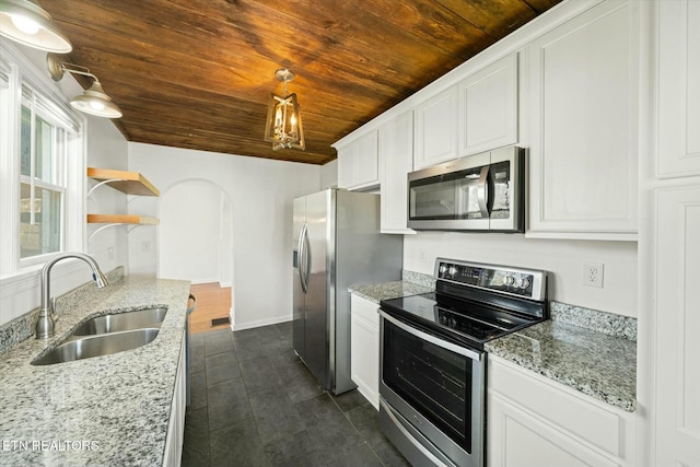 kitchen with white cabinets, arched walkways, wooden ceiling, a sink, and appliances with stainless steel finishes