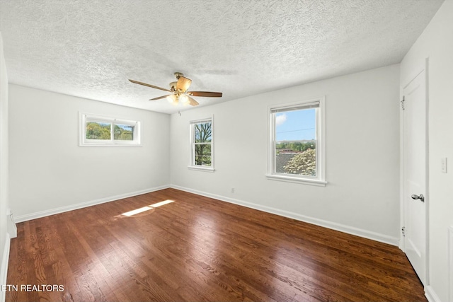unfurnished bedroom with ceiling fan, a textured ceiling, dark wood-style flooring, and baseboards