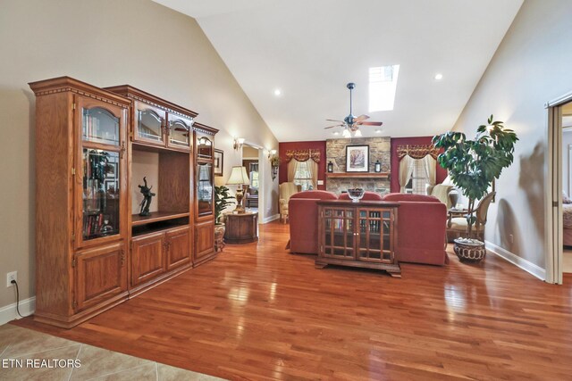 10 Claremont Cir, Fairfield Glade, TN 38558 - living area featuring high vaulted ceiling, wood finished floors, a skylight, ceiling fan, and baseboards
