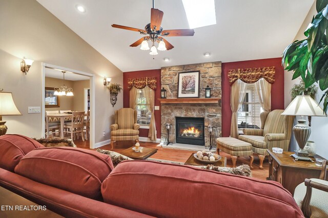 10 Claremont Cir, Fairfield Glade, TN 38558 - living area with vaulted ceiling, wood finished floors, a wealth of natural light, and a stone fireplace