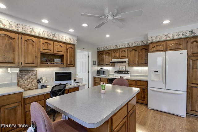 212 Tooweka Ln, Loudon, TN 37774 - kitchen with white refrigerator with ice dispenser, range with electric cooktop, under cabinet range hood, stainless steel microwave, and a ceiling fan