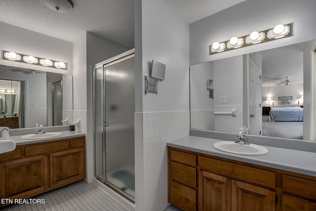 212 Tooweka Ln, Loudon, TN 37774 - bathroom with a stall shower, tile patterned floors, ceiling fan, tile walls, and two vanities