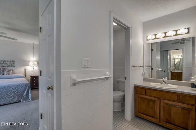 212 Tooweka Ln, Loudon, TN 37774 - ensuite bathroom featuring ceiling fan, a textured ceiling, toilet, wainscoting, and vanity