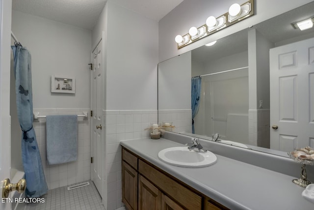 212 Tooweka Ln, Loudon, TN 37774 - full bathroom featuring a wainscoted wall, tile patterned flooring, vanity, tile walls, and a shower with curtain