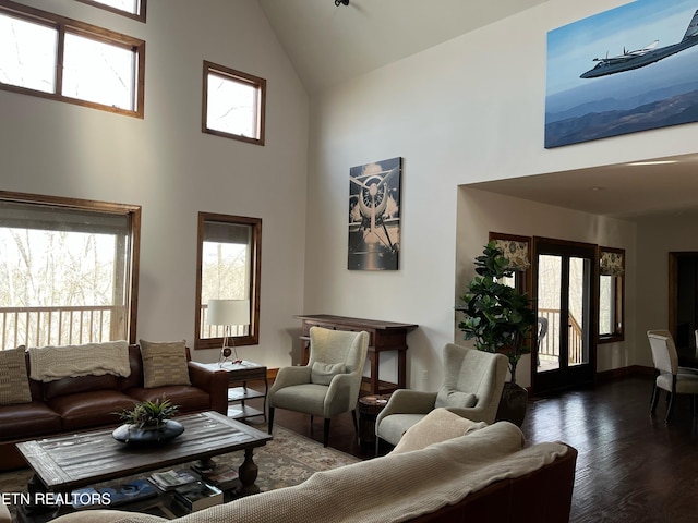 living room with wood finished floors, high vaulted ceiling, and baseboards