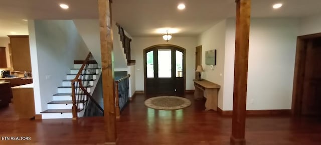 foyer featuring recessed lighting, arched walkways, wood finished floors, and stairs