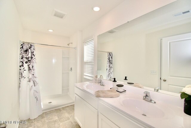 2141 Glen Crk, Knoxville, TN 37924 - full bath with a shower with shower curtain, double vanity, a sink, and visible vents