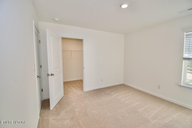 2141 Glen Crk, Knoxville, TN 37924 - unfurnished bedroom with light carpet, a walk in closet, visible vents, and baseboards