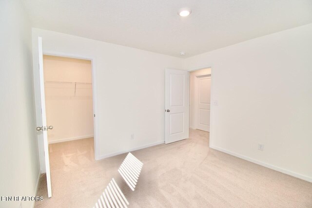2141 Glen Crk, Knoxville, TN 37924 - unfurnished bedroom with a closet, light colored carpet, recessed lighting, a walk in closet, and baseboards