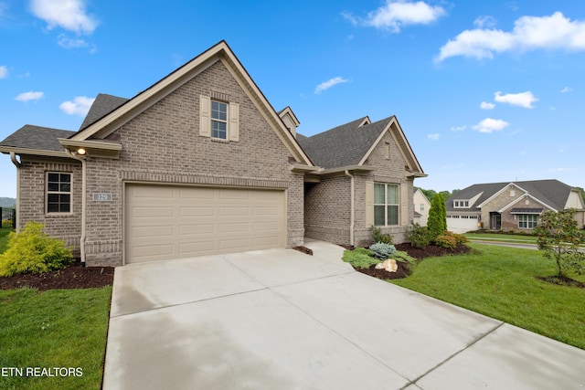 view of front of home with a garage, a front yard, brick siding, a shingled roof, and concrete driveway