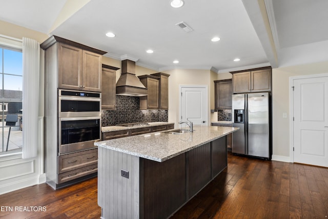 kitchen featuring custom range hood, decorative backsplash, appliances with stainless steel finishes, and visible vents