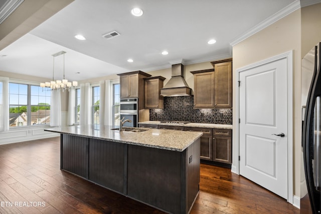kitchen featuring an inviting chandelier, visible vents, light stone countertops, custom range hood, and stainless steel appliances