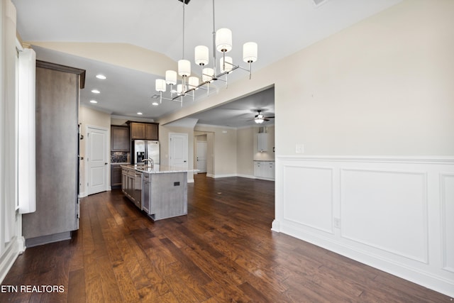 kitchen with a kitchen island with sink, dark wood-style flooring, and stainless steel fridge with ice dispenser