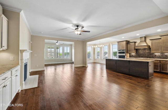 unfurnished living room featuring a high end fireplace, dark wood finished floors, baseboards, ceiling fan with notable chandelier, and ornamental molding