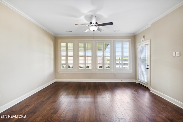spare room featuring crown molding, baseboards, ceiling fan, and dark wood-style flooring
