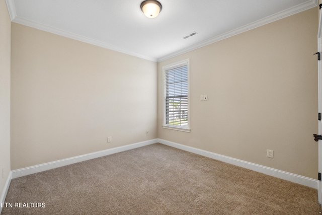 spare room featuring carpet floors, baseboards, visible vents, and ornamental molding