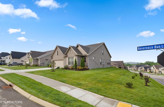view of front facade with concrete driveway, brick siding, a residential view, and a front yard