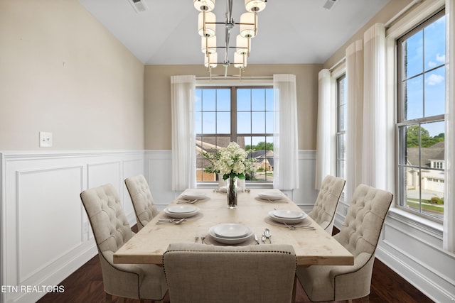 dining room featuring a chandelier, vaulted ceiling, wainscoting, and a wealth of natural light
