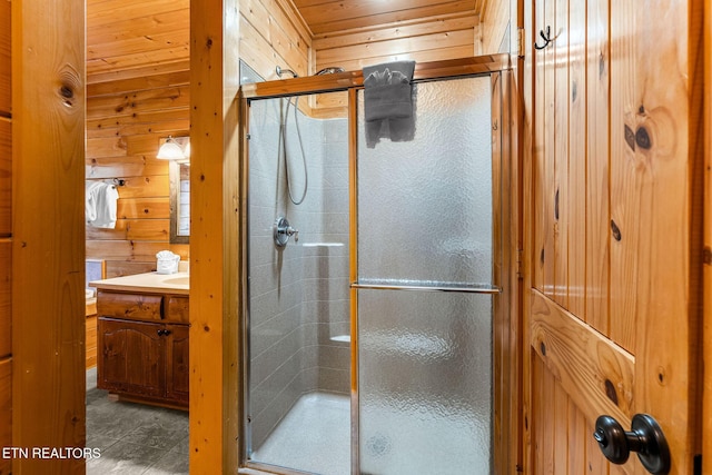 bathroom featuring wood walls, a shower stall, and vanity