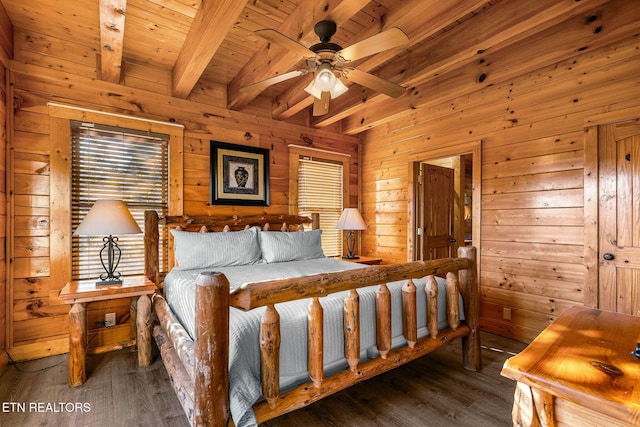 bedroom with wood walls, multiple windows, beam ceiling, and wood finished floors