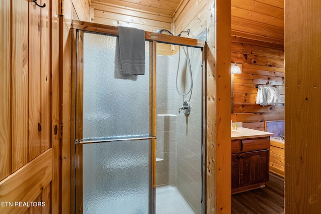 full bath featuring a shower stall, wood walls, vanity, and wood ceiling
