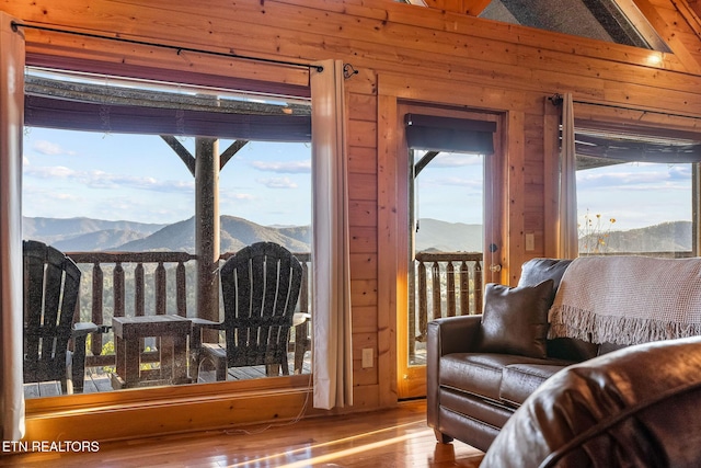 interior space with hardwood / wood-style floors, a mountain view, and wooden walls