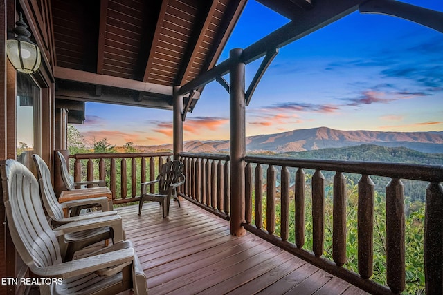 deck at dusk featuring a mountain view
