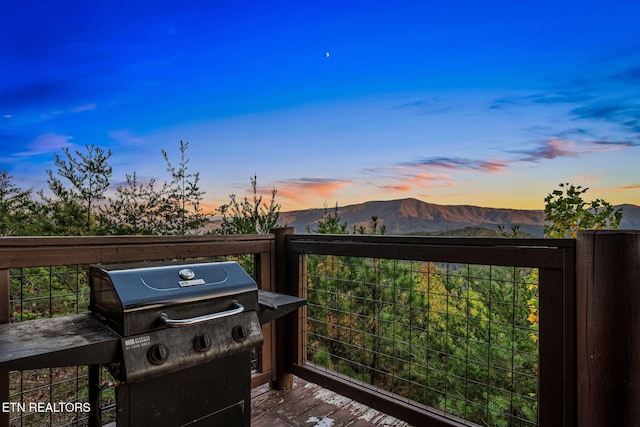 wooden terrace featuring a mountain view and a grill