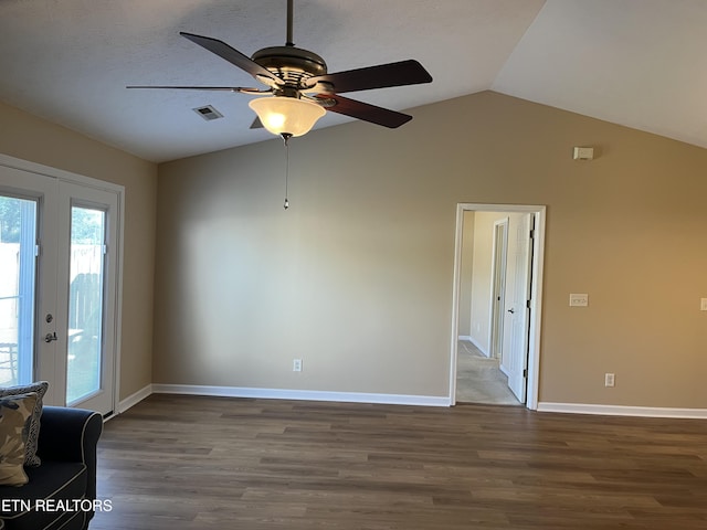 empty room featuring ceiling fan, visible vents, wood finished floors, lofted ceiling, and baseboards