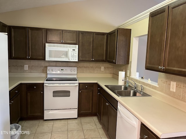 kitchen with tasteful backsplash, dark brown cabinetry, white appliances, light countertops, and a sink