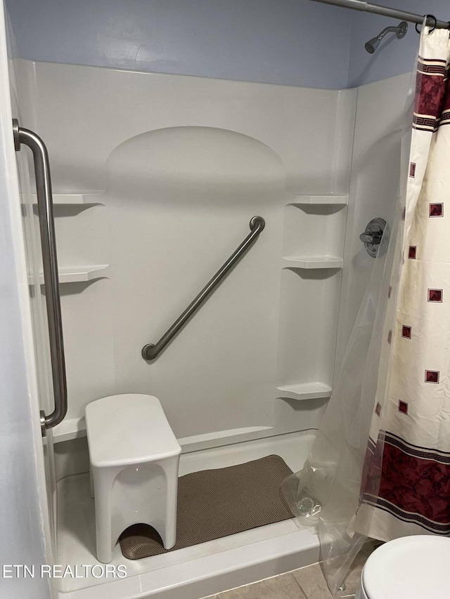 bathroom with toilet and a stall shower
