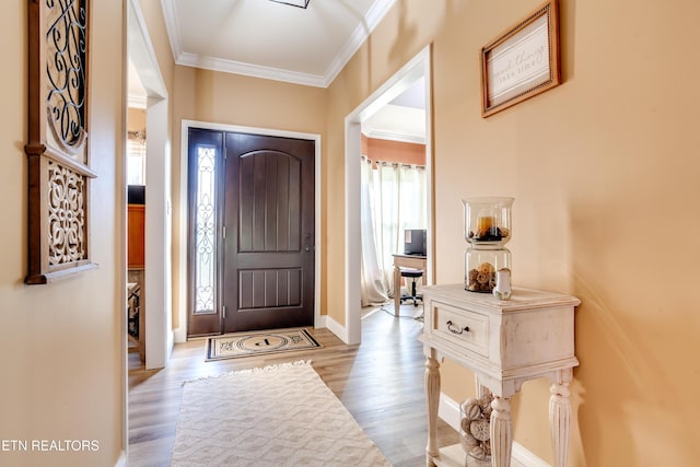 entrance foyer with baseboards, ornamental molding, and wood finished floors
