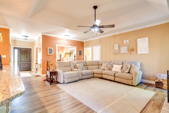 living room featuring baseboards, light wood-type flooring, crown molding, and ceiling fan