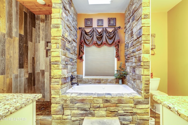 bathroom with vanity and a garden tub