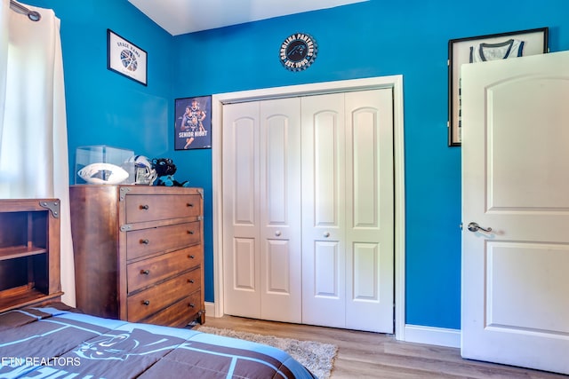 bedroom with a closet, baseboards, and wood finished floors