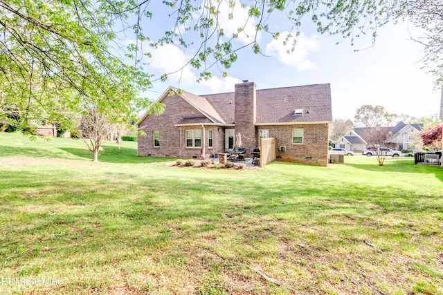 back of house with brick siding, a lawn, and a chimney