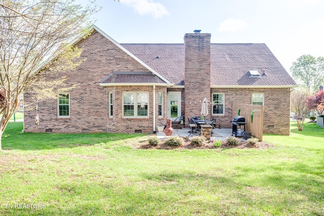 rear view of property with brick siding, crawl space, a patio, and a lawn