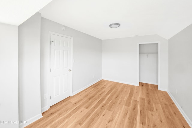 unfurnished bedroom with a closet, baseboards, and light wood-type flooring