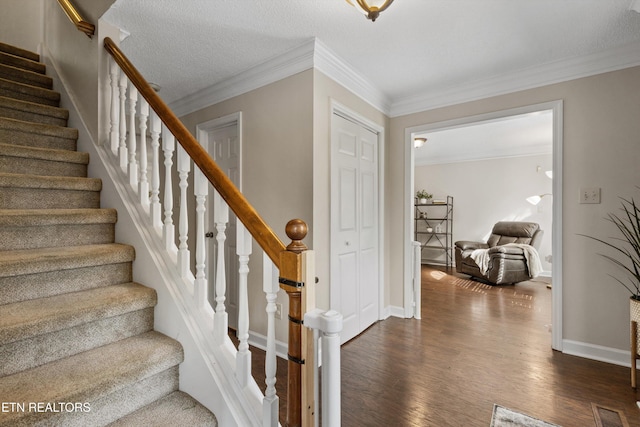 staircase featuring crown molding, baseboards, and wood finished floors