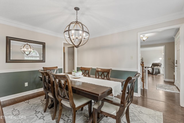 dining room featuring ornamental molding, wood finished floors, and a chandelier