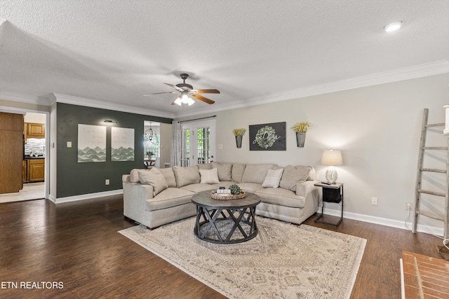 living room featuring crown molding, dark wood-style flooring, ceiling fan, a textured ceiling, and baseboards