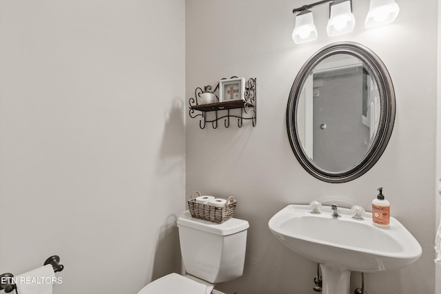 half bathroom featuring toilet and a sink