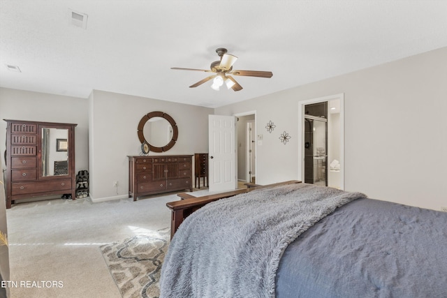 carpeted bedroom with visible vents, a ceiling fan, baseboards, and ensuite bath