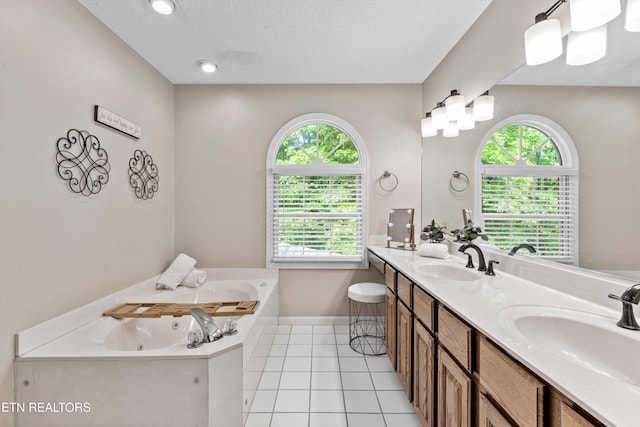 bathroom with a sink, tile patterned flooring, a tub with jets, and double vanity