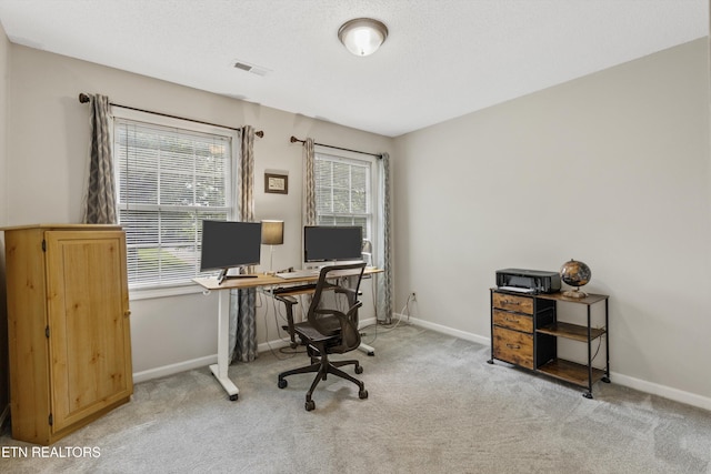 carpeted home office with baseboards, visible vents, and a healthy amount of sunlight