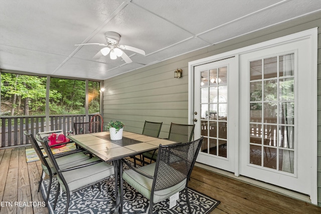sunroom / solarium featuring a healthy amount of sunlight, ceiling fan, and outdoor dining space